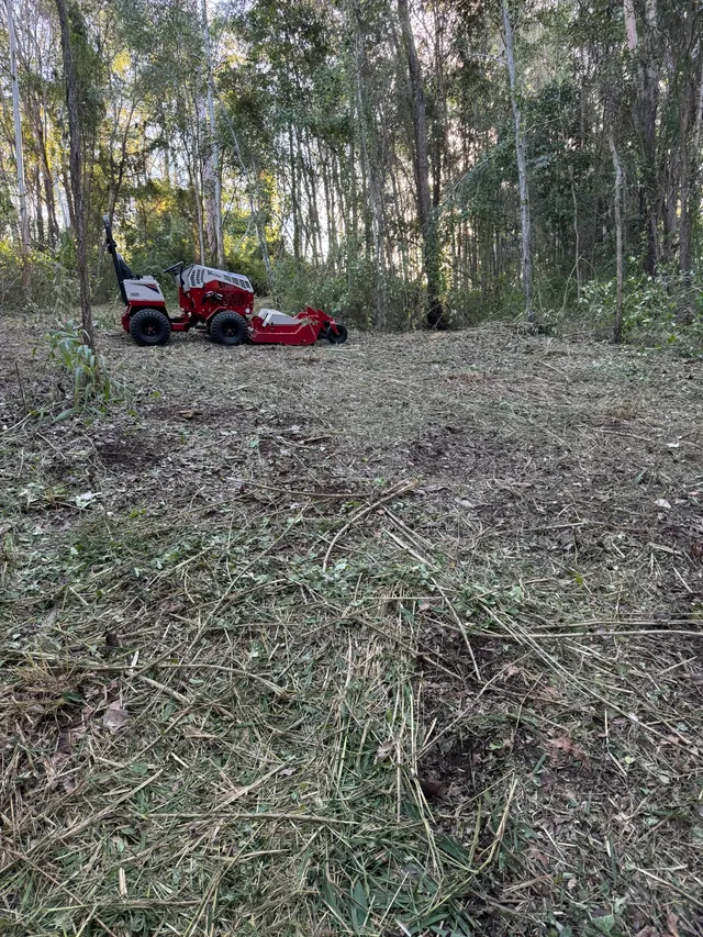 Ventrac 4520P beyond an area of lantana and scrub cut back to open ground, Pullenvale